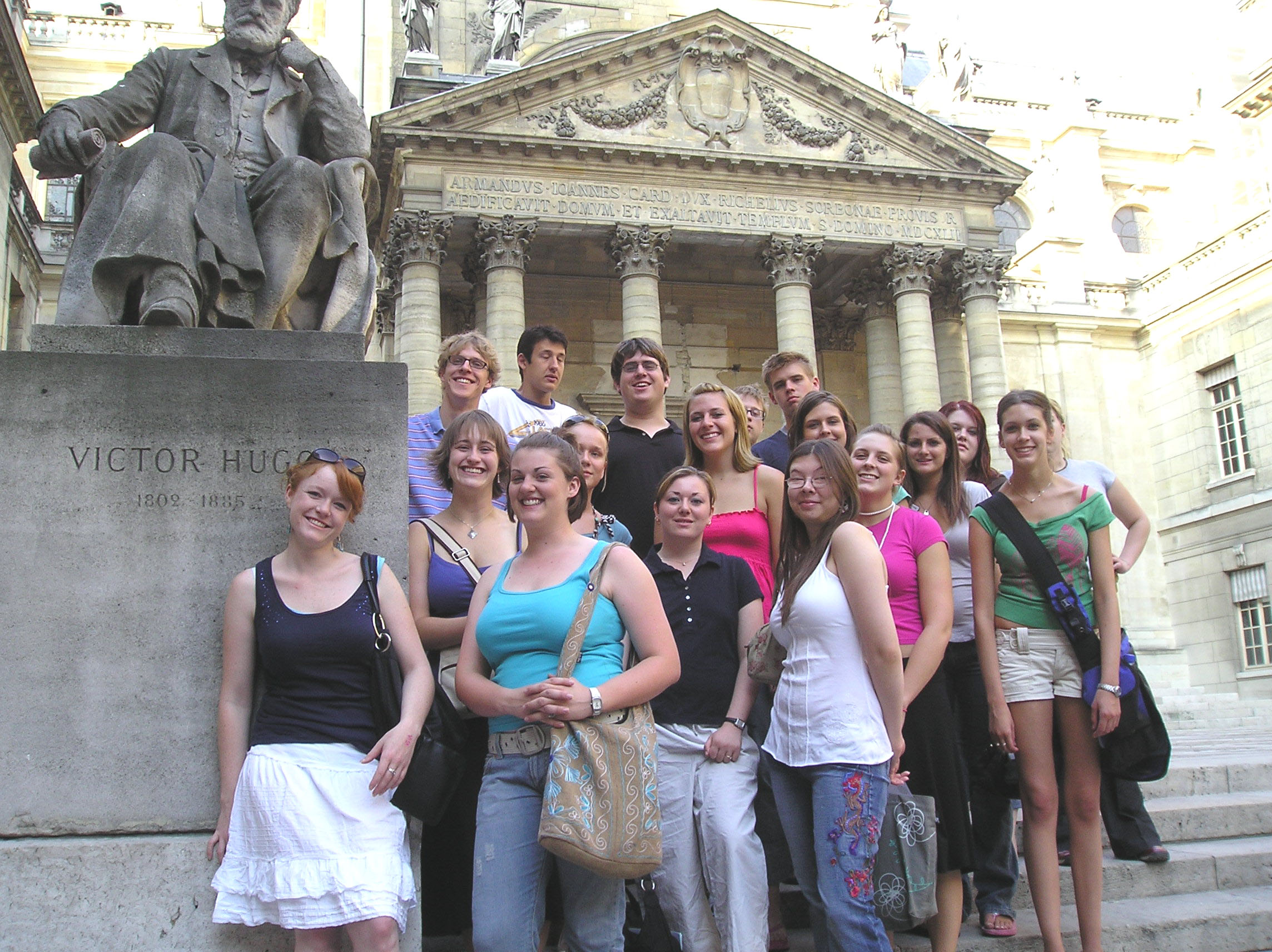 Students by a statue of Victor Hugo at the Sorbone